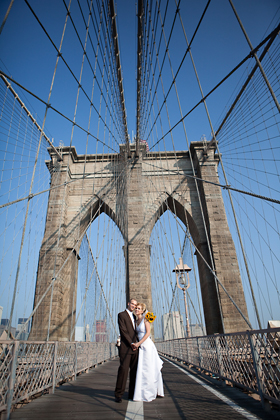 A wedding couple on a bridge posing